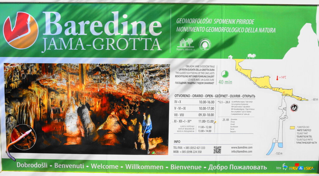 Interior of Baredine Cave featuring illuminated stalagmites, stalactites, and an underground lake.